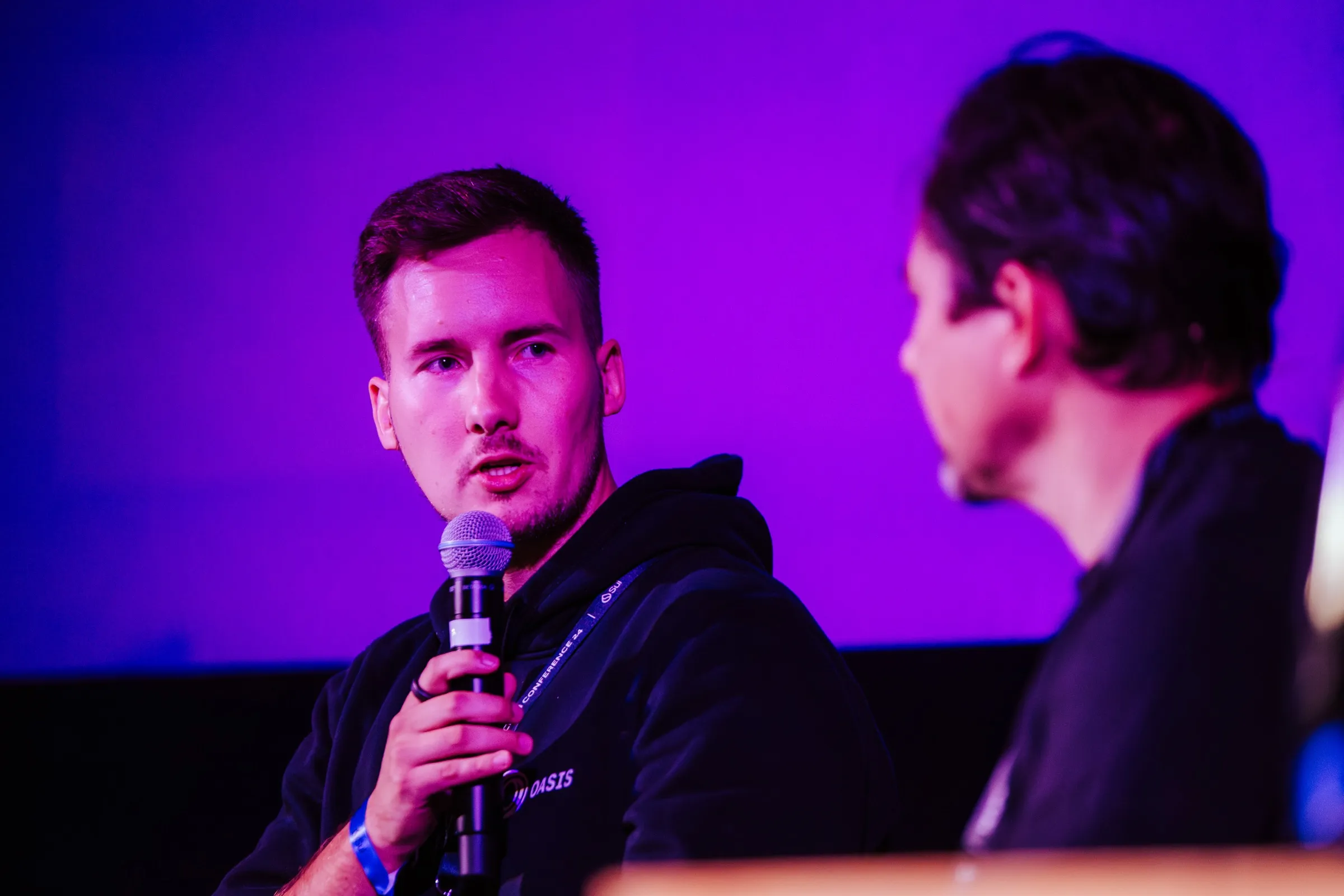 Marko speaking into a microphone on a conference stage